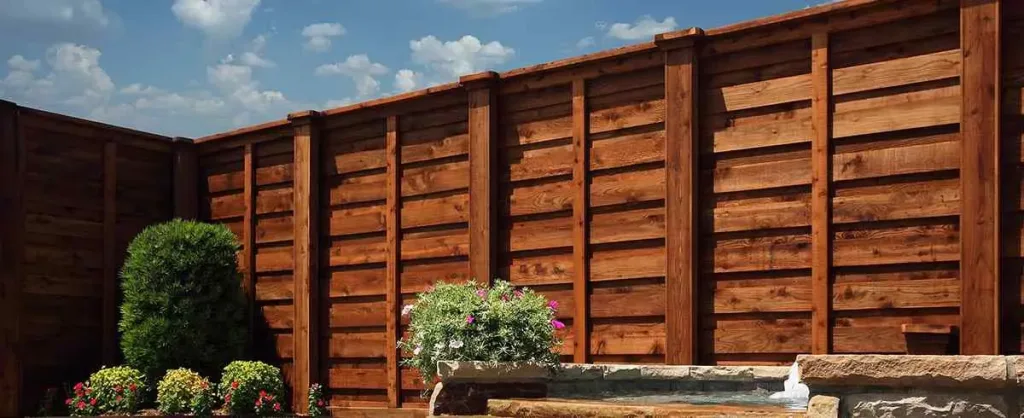 Evergreen Deck & Fence Company installing modern wooden fencing for residential property